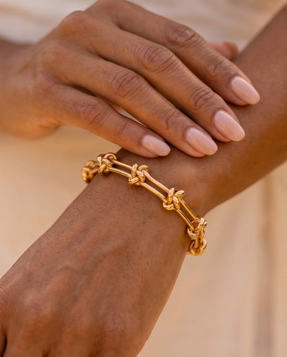 Ennvy Accessories Poised Bracelet: polished gold-plated stainless steel with knot detailing and lobster clasp.